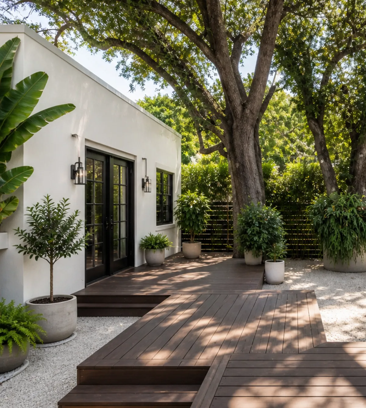 Los Angeles backyard ADU by Only The Best ADU with white stucco exterior, wood deck, outdoor barbecue area, mature trees, and private landscaped living space
