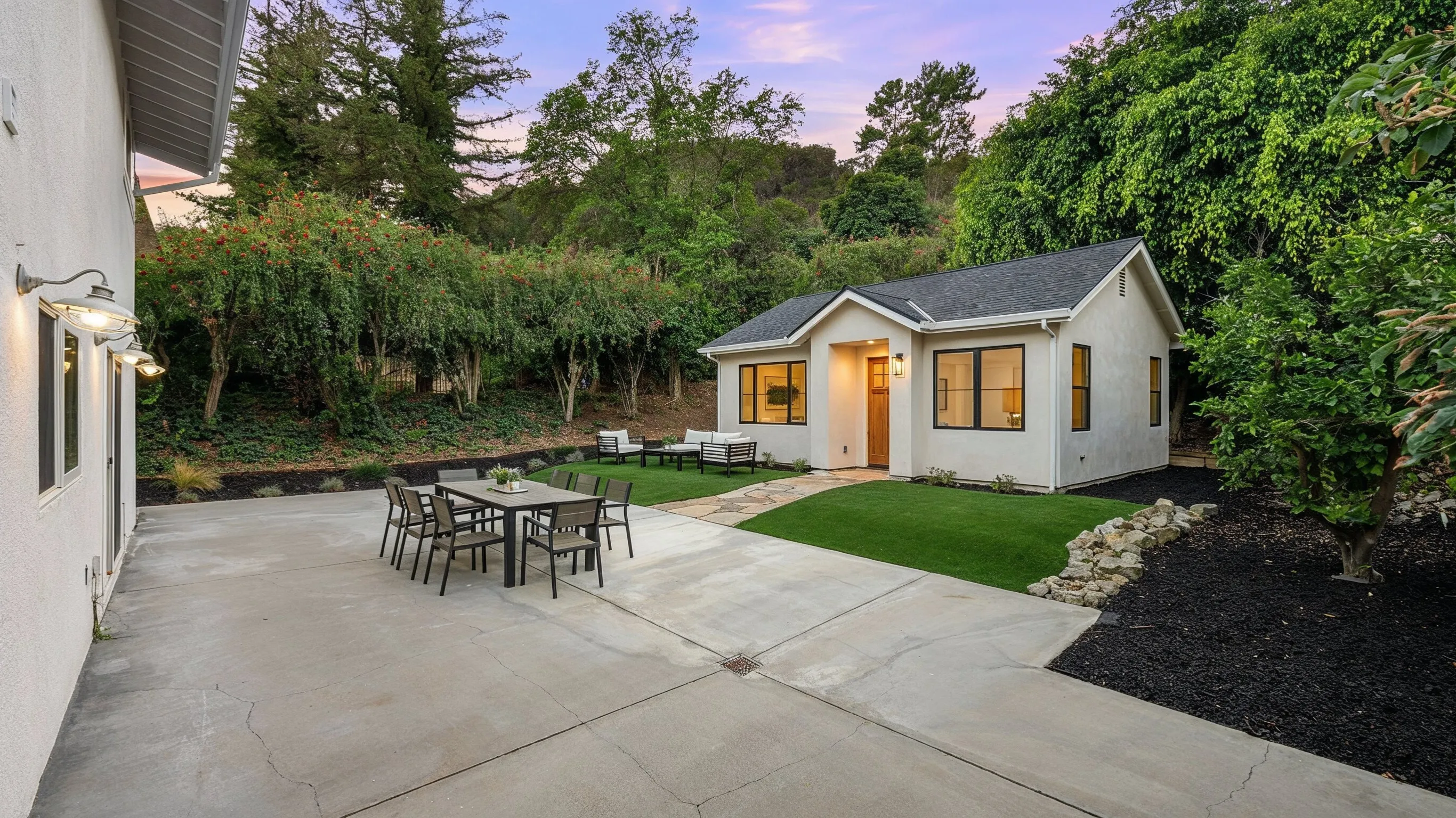 Detached ADU project in Los Angeles featuring a private backyard accessory dwelling unit with stucco exterior, black framed windows, patio seating, and landscaped outdoor space