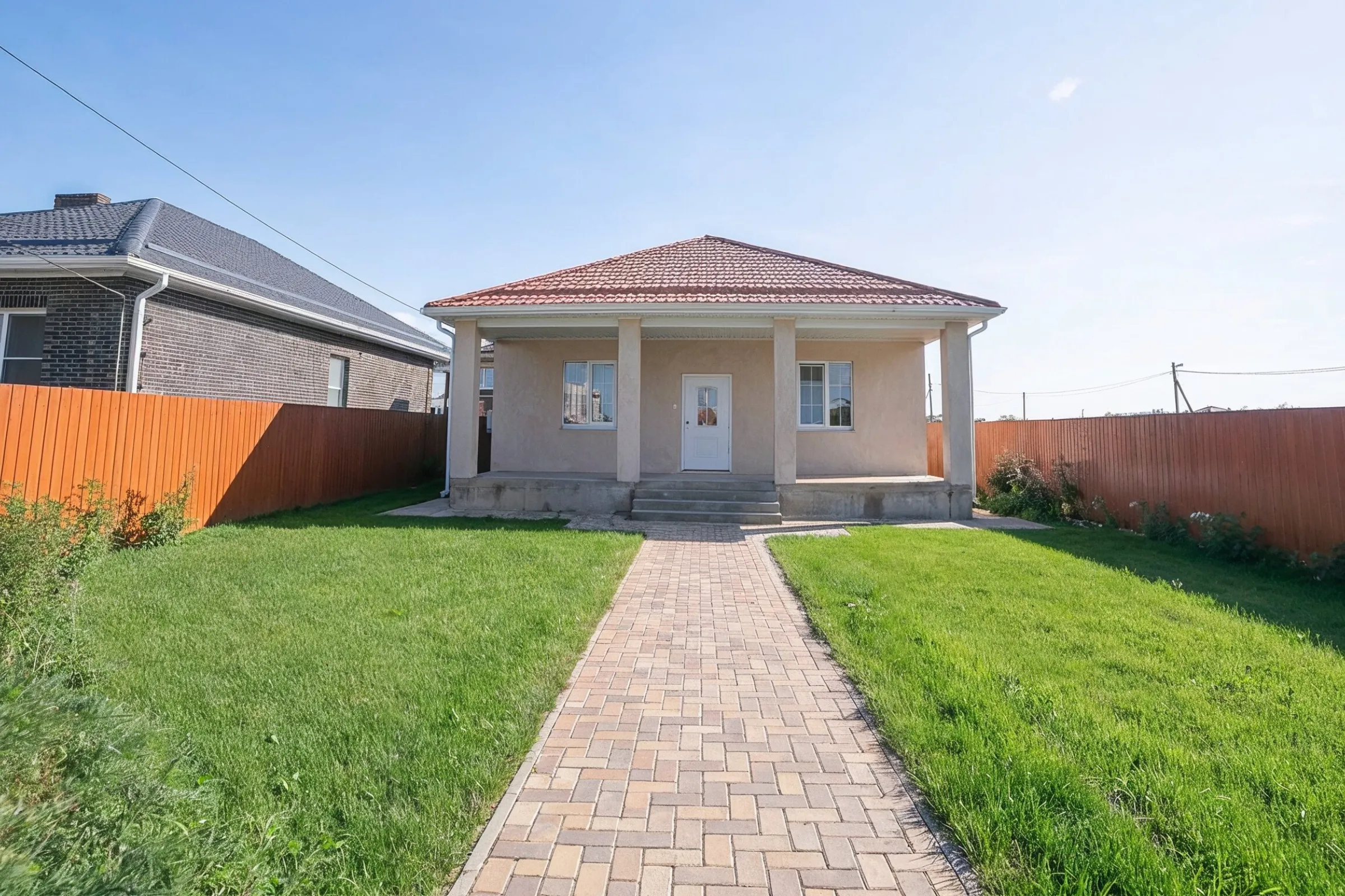 Detached ADU builders in Los Angeles finished backyard unit with front porch, paved walkway, lawn, and private fenced yard